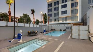 Alberca al aire libre, sombrillas en la alberca y camastros