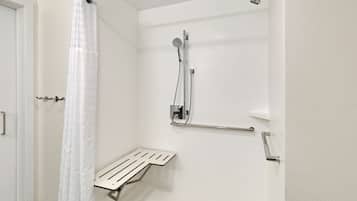 Ein modernes Badezimmer mit Dusche, Haltegriff und Handtuchhalter.