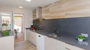 A modern kitchen with a built-in dishwasher, stainless steel sink, and a gas stove. - Beautiful  villa for 6 guests with private pool, WIFI, A/C, TV and patio (Calafell)