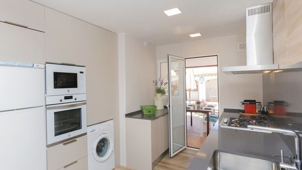 A compact kitchen with a built-in oven, microwave, and washing machine. - Beautiful  villa for 6 guests with private pool, WIFI, A/C, TV and patio (Calafell)