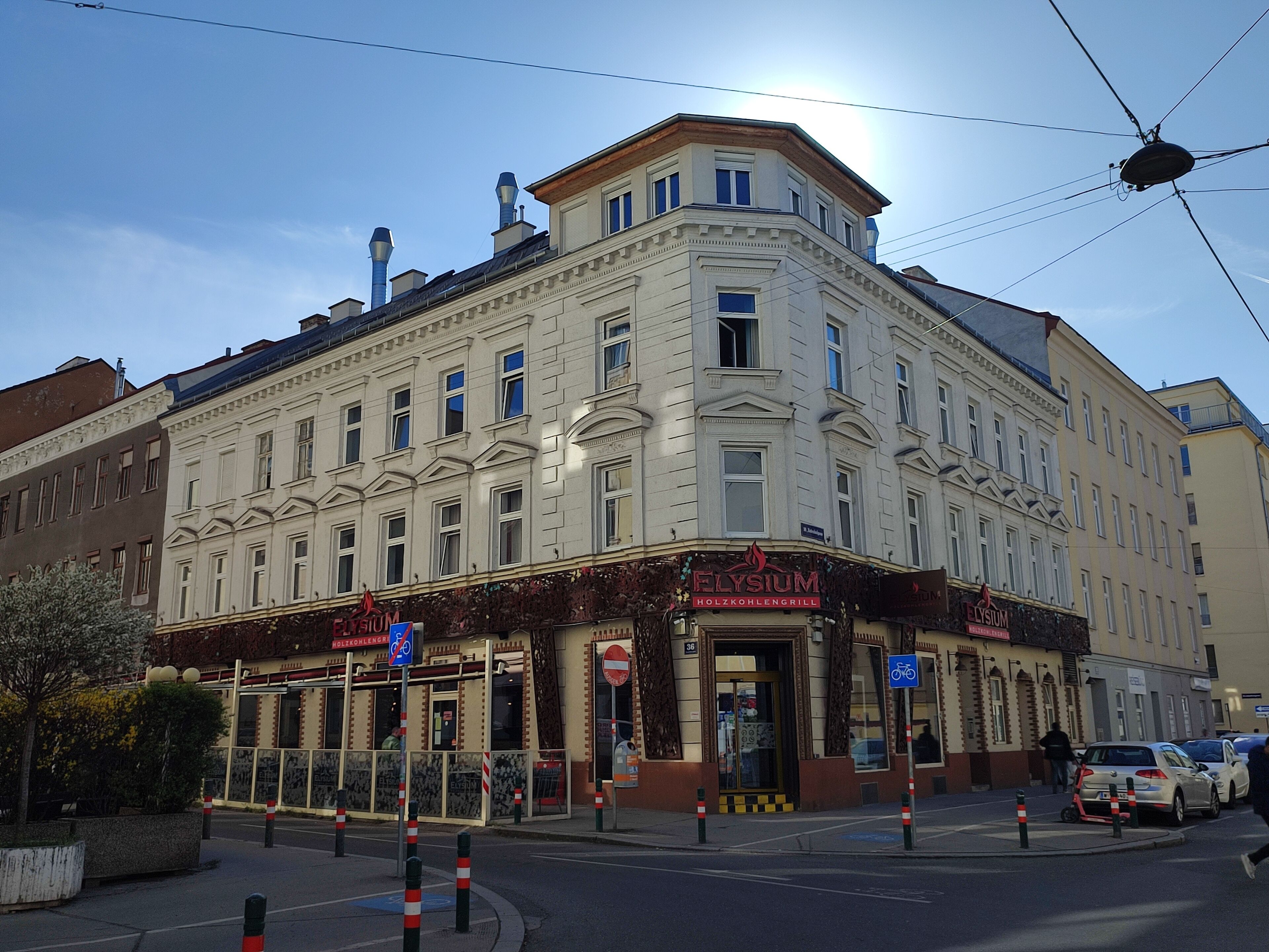Um edifício de esquina com um restaurante chamado 'Elysium' no andar térreo.