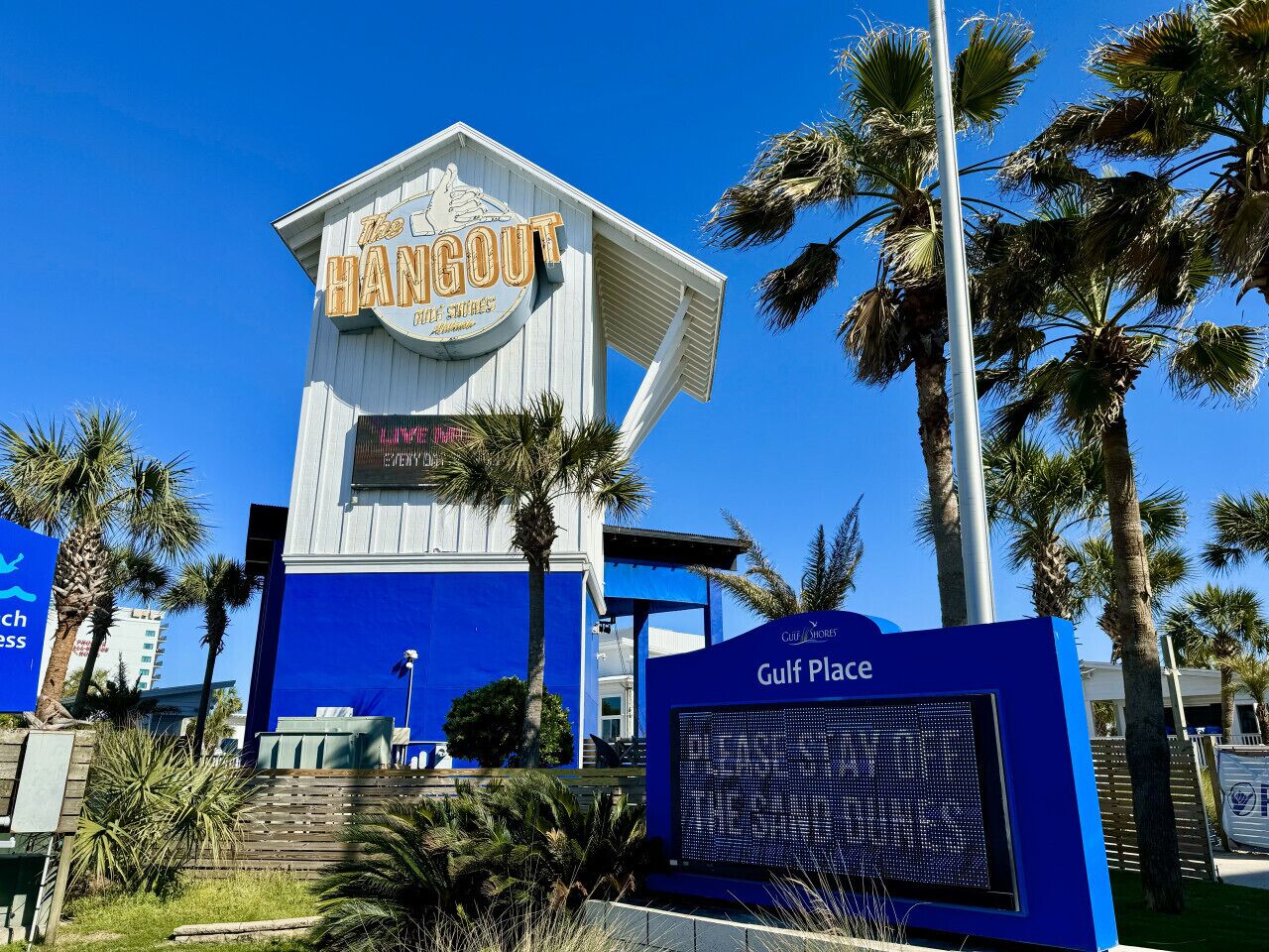 A building with a sign reading "The Hangout" and "Gulf Place" indicating a hotel or resort.
