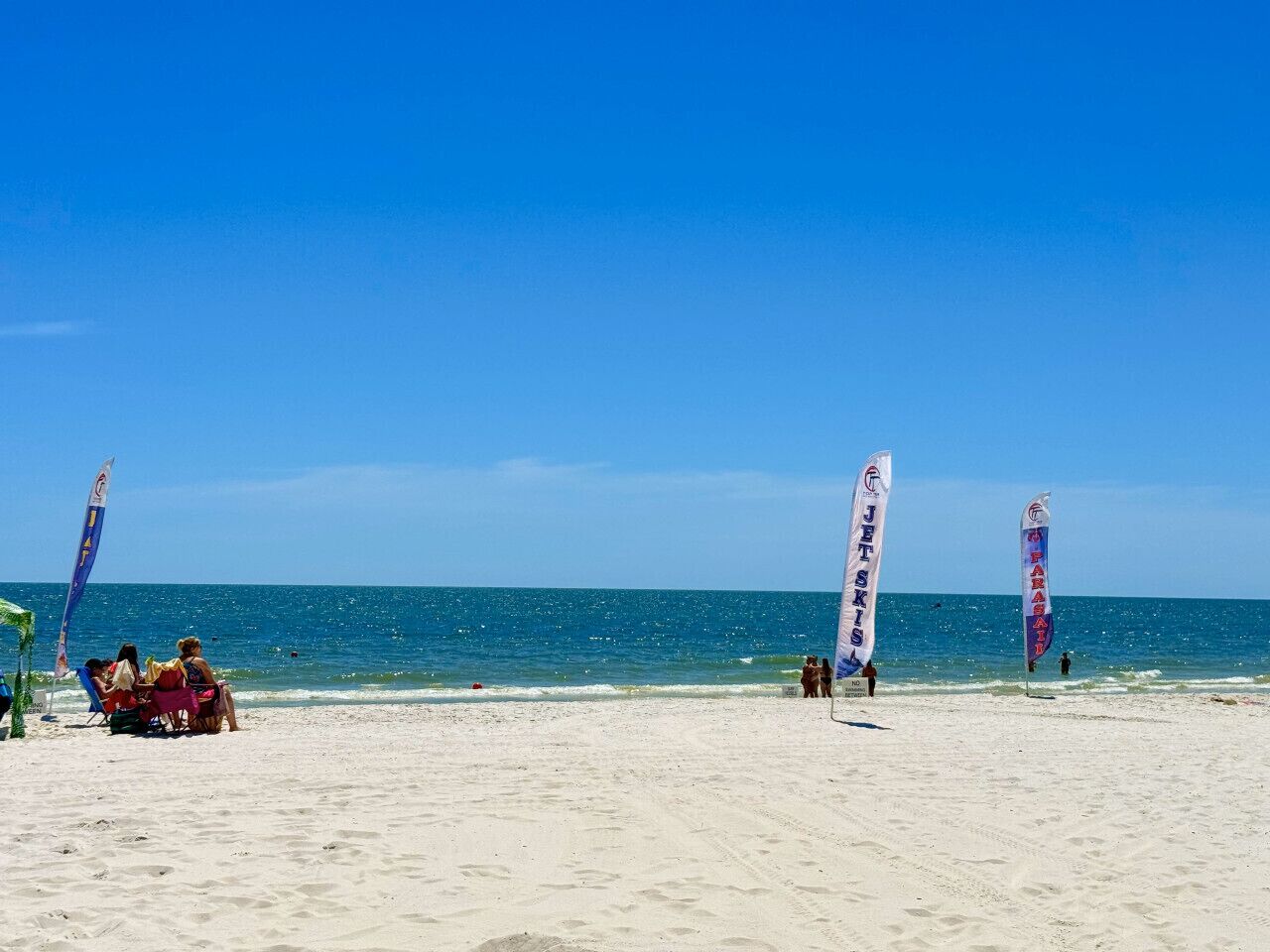 Une plage avec des drapeaux et des gens.