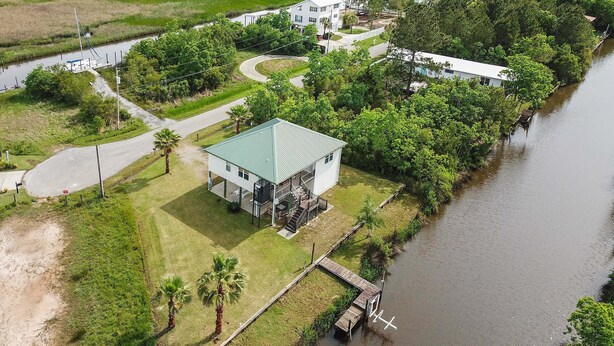 Une maison avec un toit végétalisé, un quai et une rivière.