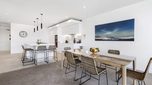 A modern kitchen with white cabinetry, a central island, and pendant lighting.