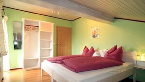 Une chambre à coucher avec un lit, une armoire et une porte.