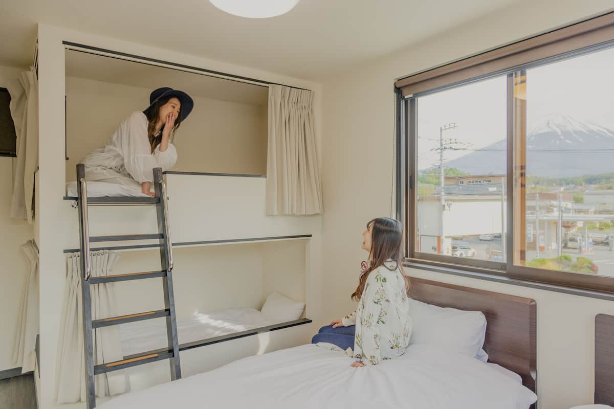 A bunk bed room with a view of a mountain and a cityscape.