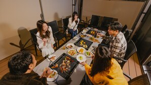 A group of people dining outdoors at a table with various dishes, including grilled food and salads. - Furinkazan Katsuyamajuku (Fujikawaguchiko)