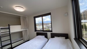 A room with bunk beds, a window with a view of a town and mountains, and a ceiling light. - Furinkazan Katsuyamajuku (Fujikawaguchiko)