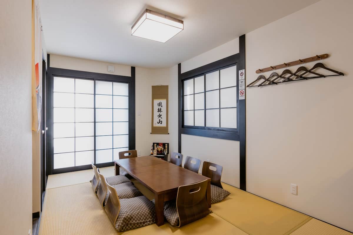 A traditional Japanese-style room with tatami flooring, a wooden table, and shoji screens.