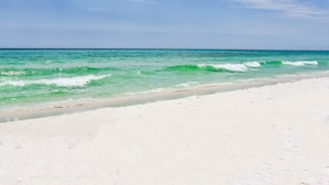 Une plage à l’eau turquoise et au sable blanc.