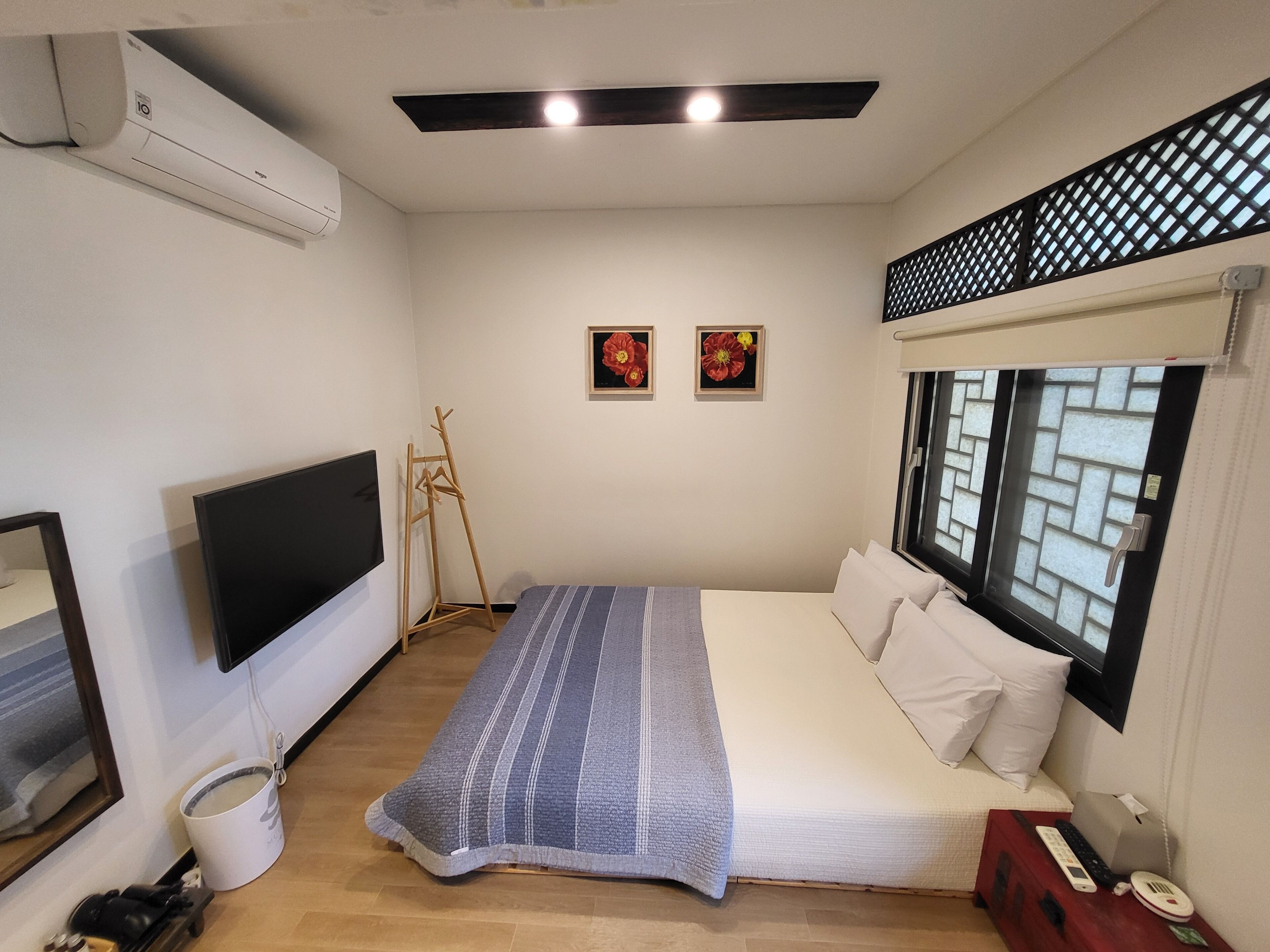 Un dormitorio con cama, televisión, ventana con vistas y escalera de madera.