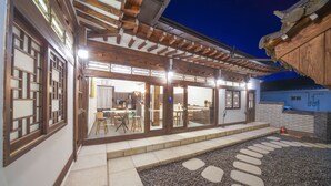 A traditional Japanese-style building with wooden beams and sliding doors, a stone pathway, and a small garden area. - Naganjae (Gyeongju)