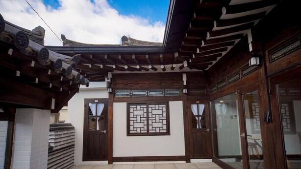 A traditional Japanese-style building with wooden beams, a tiled entrance, and a decorative screen. - Naganjae (Gyeongju)