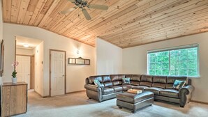 A spacious living room with a large leather sectional sofa, a wooden cabinet, and a ceiling fan. - 4 Mi to Big Tree State Park: Serene Cabin w/ Deck (Arnold)