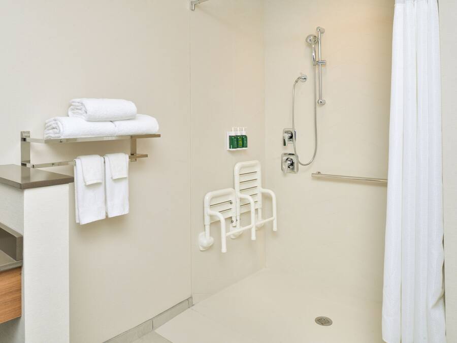 Une salle de bain d’hôtel équipée d’une douche, d’un porte-serviettes et de toilettes.