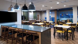 A modern dining area with a central island, multiple tables, and chairs. - Fairfield Inn & Suites by Marriott Charlotte University Research Park (Charlotte)