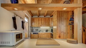 A kitchen with wooden cabinets, a white countertop, a microwave, and a coffee maker. - Chalet Claire de Soleil - La Tzoumaz, 4 Vallees (La Tzoumaz)