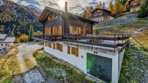 A modern chalet with a wooden exterior, large windows, and a balcony overlooking a mountainous landscape. - Chalet Claire de Soleil - La Tzoumaz, 4 Vallees (La Tzoumaz)