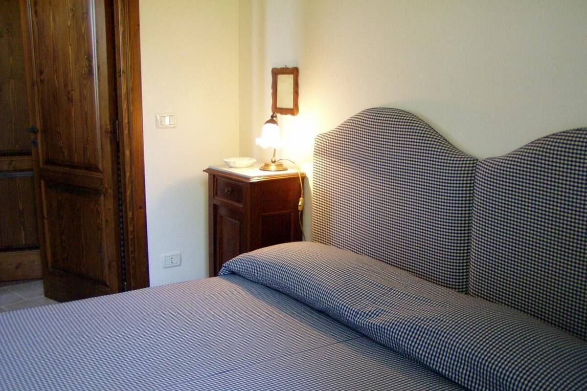 Une chambre à coucher avec un lit, une table de chevet, une lampe et une porte en bois.