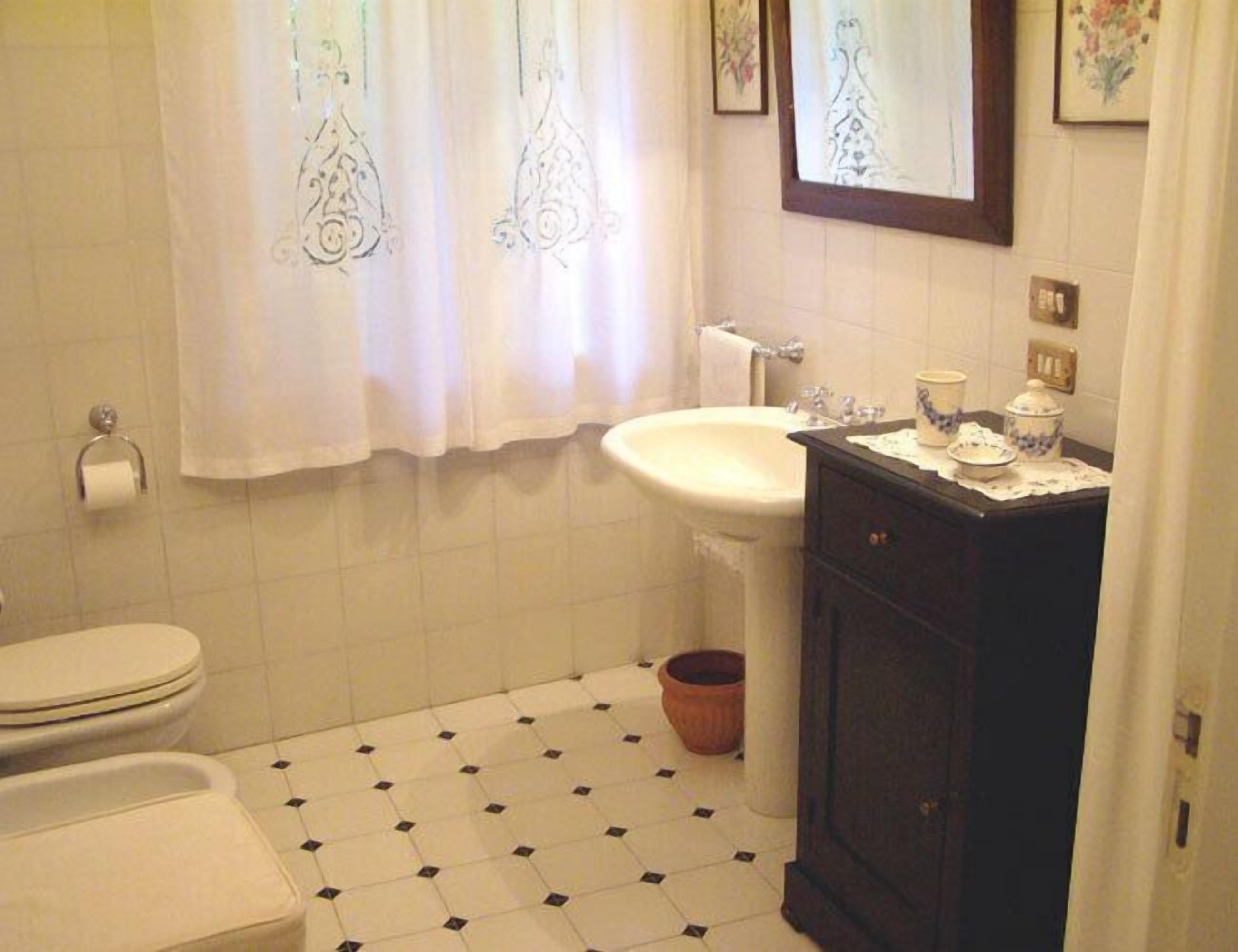 Un baño con inodoro, lavamanos y tocador.