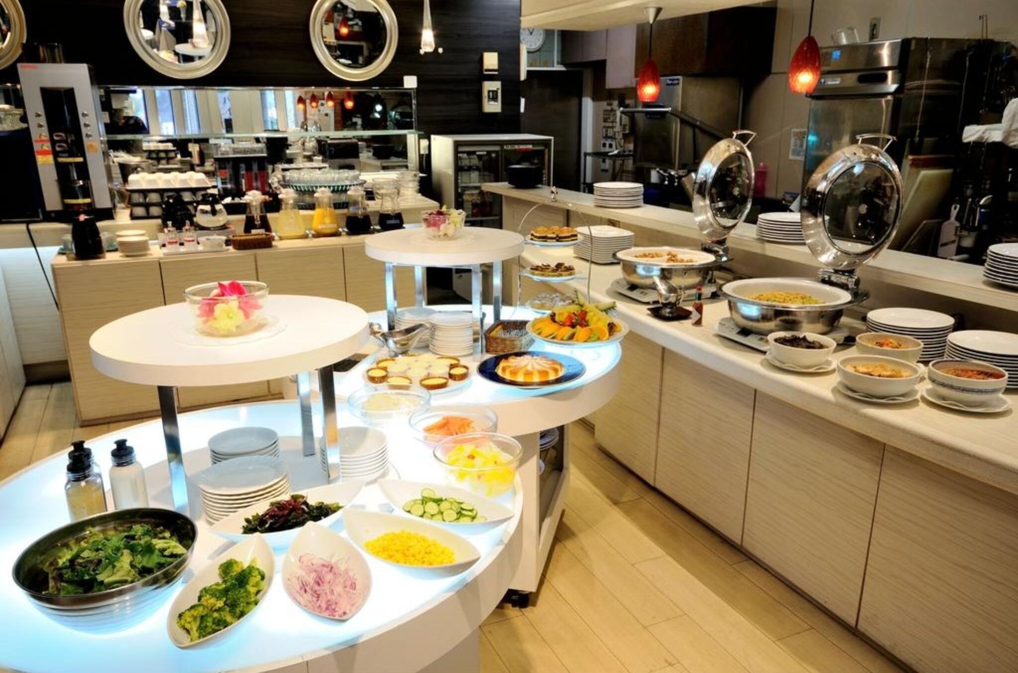 Ein reichhaltiges Buffet mit verschiedenen Speisen und einer modernen Küche im Hintergrund.