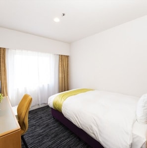 Relax in a cozy space with a comfortable bed, desk, and window with curtains.