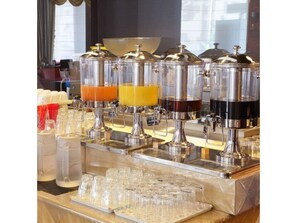 Enjoy a refreshing drink at our beverage station, equipped with multiple dispensers and a selection of glasses.