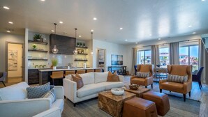 A modern living room with a sofa, armchairs, and a coffee table. There is a kitchen area with a dining table and chairs. - Poolside | Near Pickleball Courts | Shuffleboard | Arcadia #14 (Santa Clara)