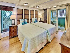 A hotel room with two beds, wooden headboards, a wooden dresser, and a view of the outside. - Sacred South Maui Beach House Sweeping Ocean Views Hot Tub Turtle Shore (Kihei)
