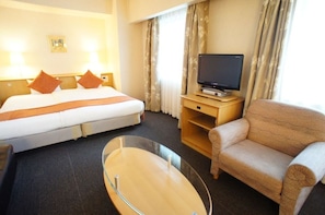 Relax in comfort with a large bed, flat-screen TV, and cozy seating area.