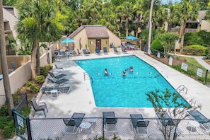 A swimming pool with lounge chairs and palm trees. - Stylish Beach Retreat Walk to the Sand from Beach (Hilton Head Island)