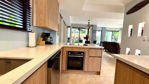 Een moderne keuken met houten kastjes, een vaatwasser en een inbouwoven.