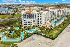 A hotel with multiple buildings, a swimming pool area, and a parking lot.