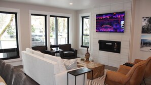 A modern living room with a white sofa, two armchairs, a coffee table, and a fireplace. - Stunning Downtown Home on Sherman Avenue (Coeur d'Alene)