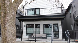 A modern two-story building with a balcony, large windows, and a bench outside. - Stunning Downtown Home on Sherman Avenue (Coeur d'Alene)