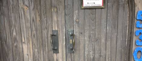 A wooden door with a plaque and a mailbox.