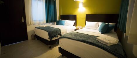 A hotel room with two beds, a window with curtains, an air conditioning unit, and a tiled floor.