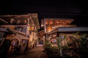 A nighttime view of a restaurant with outdoor seating, a covered patio, and a sign that reads "Motel." - Asilé Hotel Boutique (Bacalar)