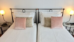 A double bed with white linens, two bedside tables with lamps, and a pink throw blanket. - Cosy  Apartment at Lido with Pool (Funchal)