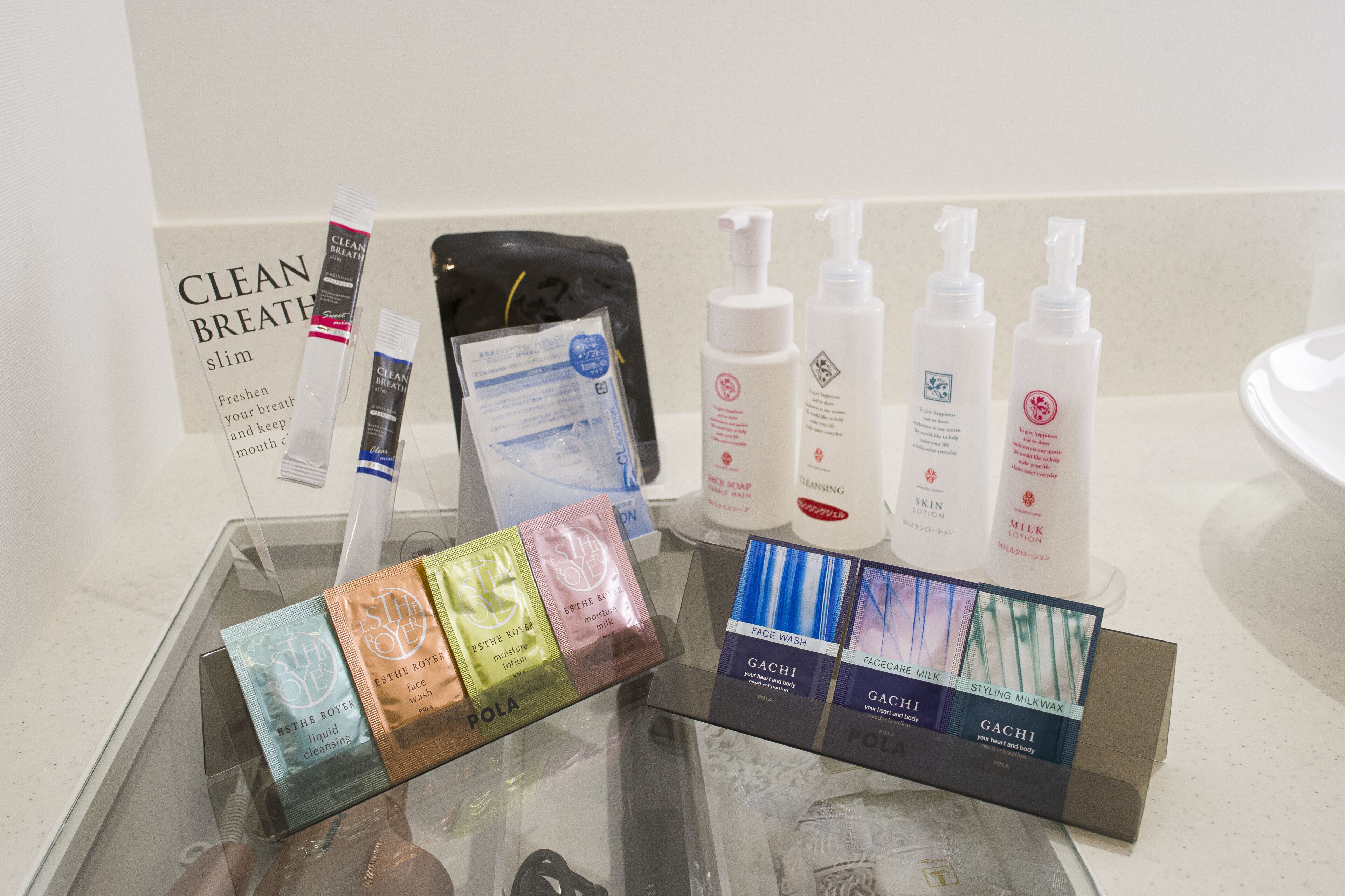A bathroom counter with various toiletries and a sign that reads "CLEAN BREATH slim".
