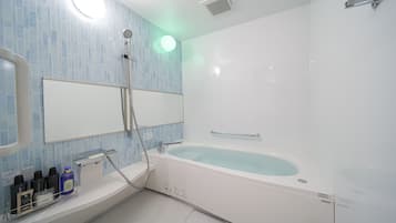 Un baño moderno con una bañera grande, ducha y tocador con artículos de aseo.