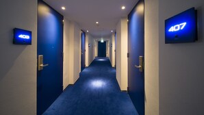 Ein Hotelgang mit Türen, die mit 403 und 407 nummeriert sind und zu Zimmern führen.