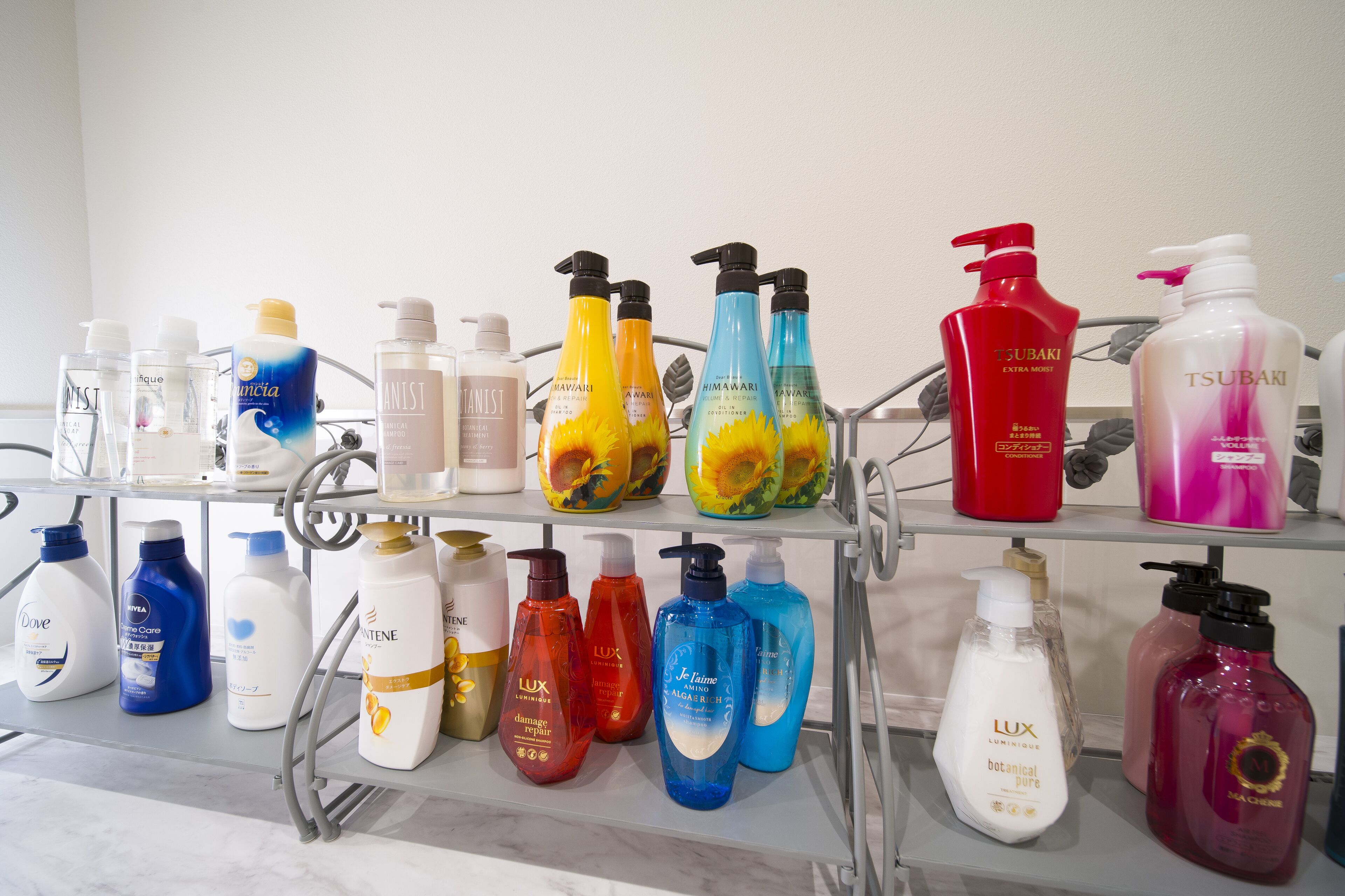 A variety of toiletries on a shelf, including brands like Dove, Lush, and TSUBAKI.