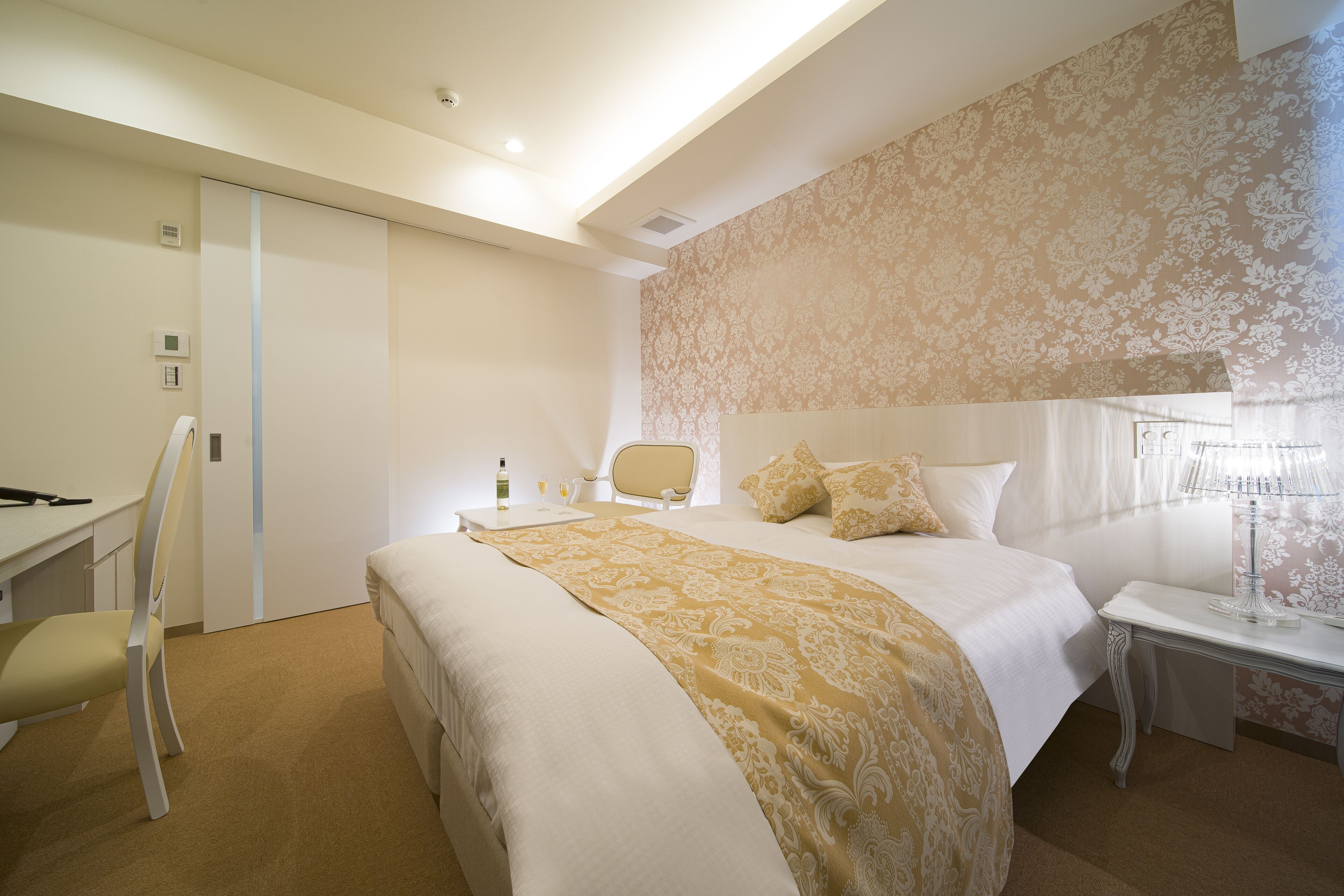 Una habitación de hotel con una cama grande, un escritorio y una silla.