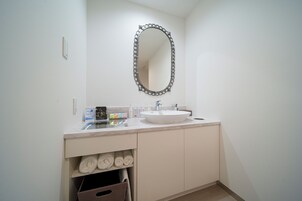 Un baño con un lavabo blanco, un espejo y un perchero para toallas.