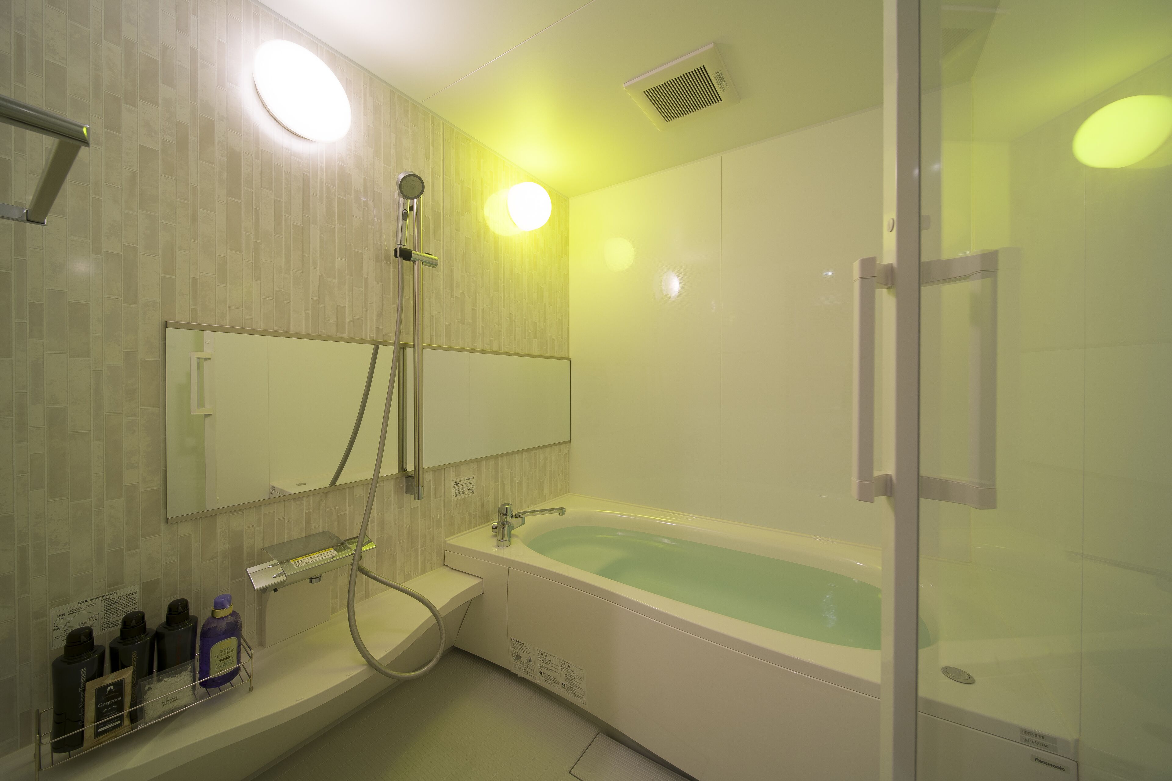 A modern bathroom with a large bathtub, a glass shower enclosure, and a vanity with toiletries.