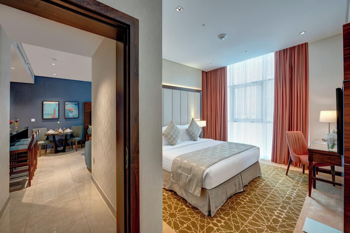 Une chambre d’hôtel comprenant un lit, un bureau, une chaise et un coin repas avec des chaises et une table.