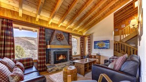 A cozy living room with a fireplace, plaid curtains, and a view of the mountains. - Chalet Khione - La Tzoumaz, 4 Vallees (La Tzoumaz)