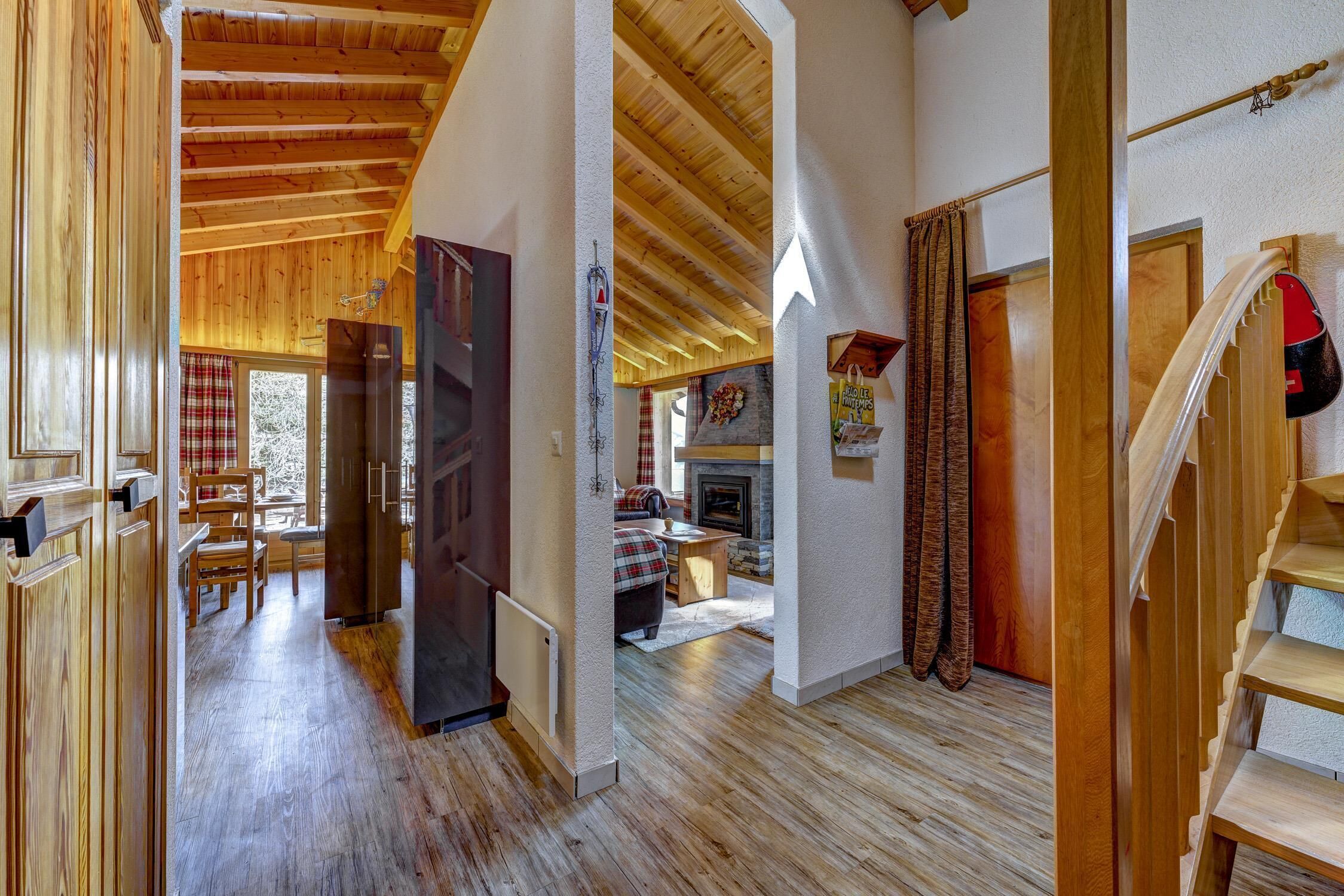 Un intérieur en bois avec un escalier, une cheminée et un coin repas.